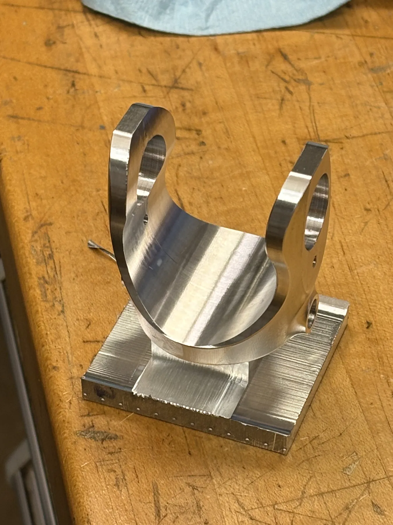 A yoke partway through machining, still attached to its stock.